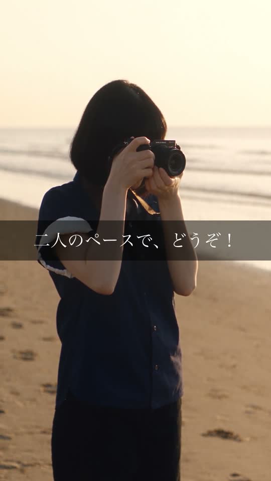 海辺でカメラを構えるカメラマン
